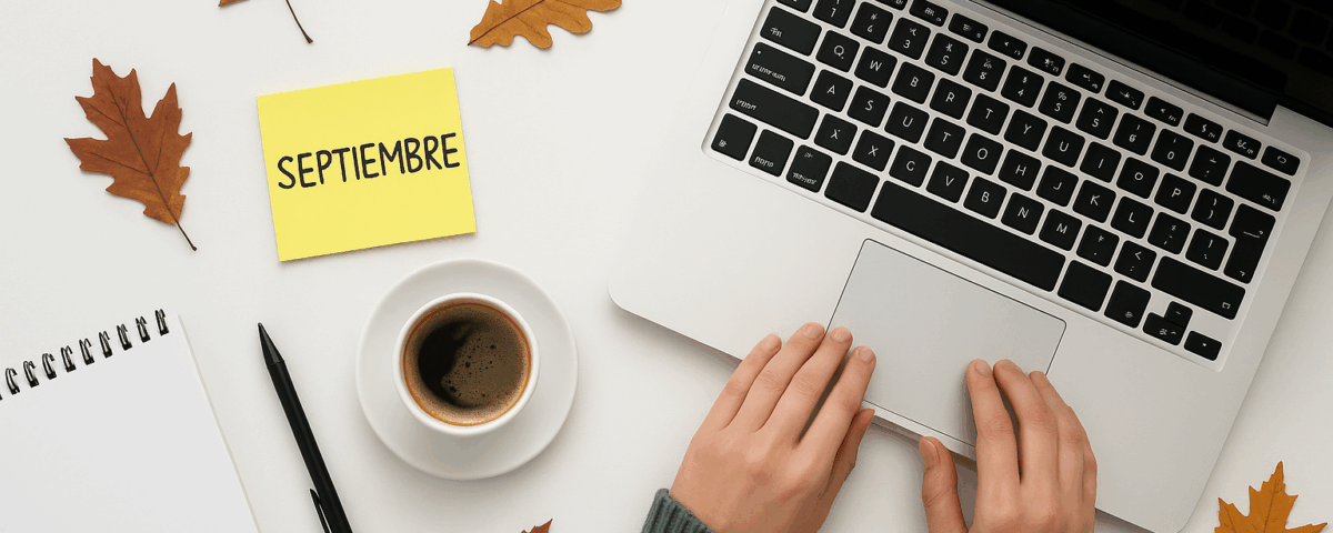 Escritorio minimalista con portátil, café, libreta y hojas otoñales, representando cómo reactivar la estrategia de marketing en septiembre tras el parón de verano.